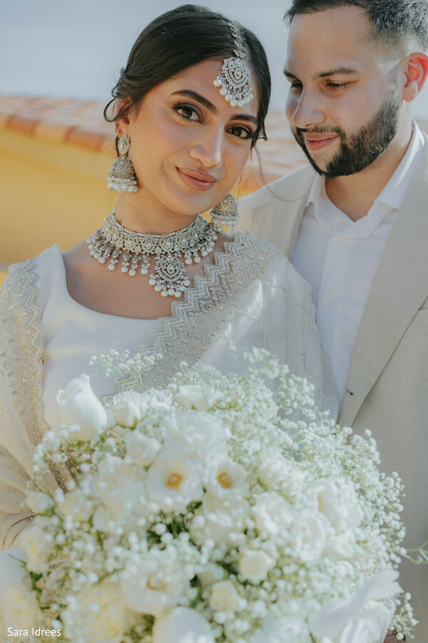 ivory sari bride,diamond bridal jewelry,white floral bouquet,intimate couple portrait,soft natural light,destination wedding elegance,modern indian bride,romantic wedding moment,luxury bridal styling,pastel wedding palette