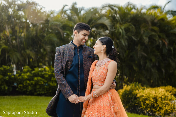south asian couple portrait,pre wedding shoot,garden setting,festive lehenga,embroidered sherwani,candid romance,destination wedding vibes,joyful expressions,cultural fashion,intimate moment