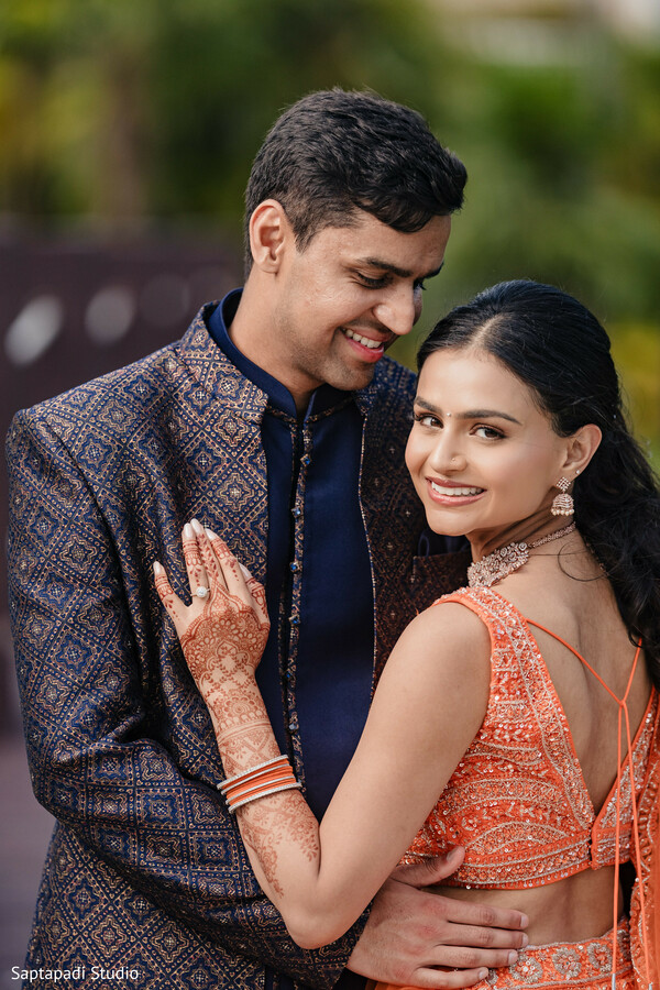 south asian couple portrait,pre wedding photos,embroidered sherwani,lehenga choli,mehndi hands,romantic embrace,luxury indian fashion,outdoor wedding portraits,cultural elegance,intimate moment