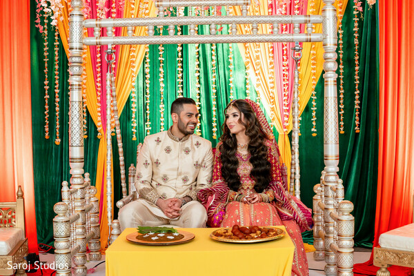 mehndi ceremony,couple portrait,indian wedding traditions,colorful wedding decor,pre wedding rituals,mehndi stage,intimate wedding moment,south asian couple,festive wedding setup,cultural celebration