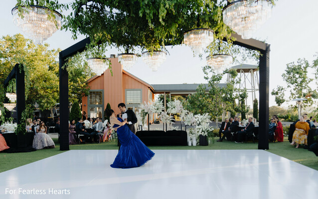 first dance,outdoor reception,crystal chandeliers,blue evening gown,wedding dance floor,romantic reception,luxury wedding decor,garden wedding,evening celebration,cinematic moment