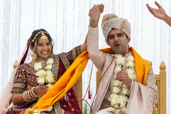 wedding recessional,newlyweds celebration,hindu wedding ceremony,joyful couple moment,floral garlands,traditional wedding attire,indian bride groom,just married vibes,ceremony finale,cultural wedding joy