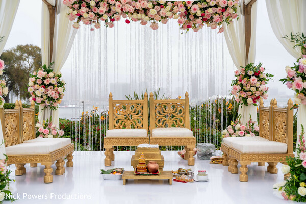 outdoor indian wedding ceremony,red bridal lehenga,waterfront mandap,floral aisle decor,bridal twirl,south asian bride portrait,pastel floral mandap,traditional bridal jewelry,luxury wedding setting,romantic ceremony moment