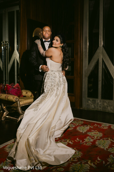indoor wedding portrait,luxury bride and groom,classic tuxedo,elegant bridal gown,heritage interiors,romantic pose,south asian fusion couple,fine art wedding photography,timeless wedding style,intimate embrace
