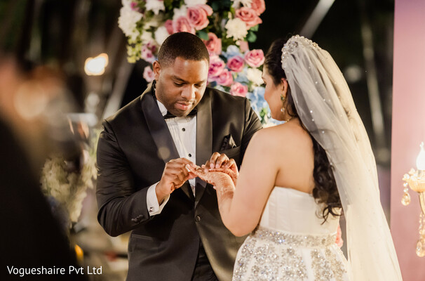 ring exchange ceremony,wedding vows moment,emotional bride,groom tuxedo,white wedding gown,floral ceremony decor,candlelit wedding,south asian fusion ceremony,intimate vows,luxury wedding ritual