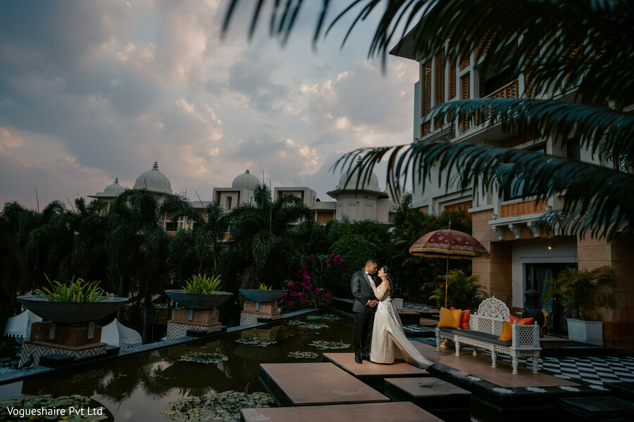 palace courtyard wedding,sunset couple portrait,luxury destination wedding,water reflection decor,south asian fusion wedding,elegant bride and groom,heritage venue,romantic architecture,evening light photography,intimate wedding moment