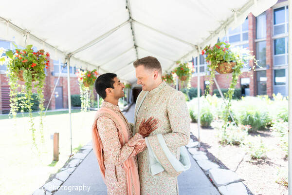 same sex indian couple,romantic wedding portrait,outdoor walkway,intimate couple moment,south asian wedding love,candid affection,pastel sherwani style,modern indian wedding,emotional connection,natural light romance