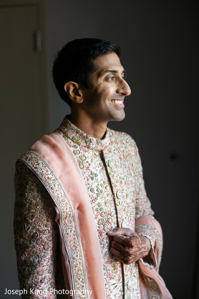groom portrait,sherwani details,getting ready moment,natural window light,pastel wedding attire,indian groom style,intimate pre ceremony,mehndi on groom hands,luxury south asian wedding,serene wedding moment