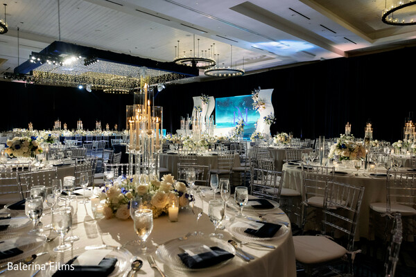 luxury wedding reception decor,candle centerpiece styling,elegant ballroom wedding,crystal chiavari chairs,ivory floral arrangements,grand wedding stage design,south asian reception decor,upscale wedding tablescape,dramatic reception lighting,destination luxury wedding