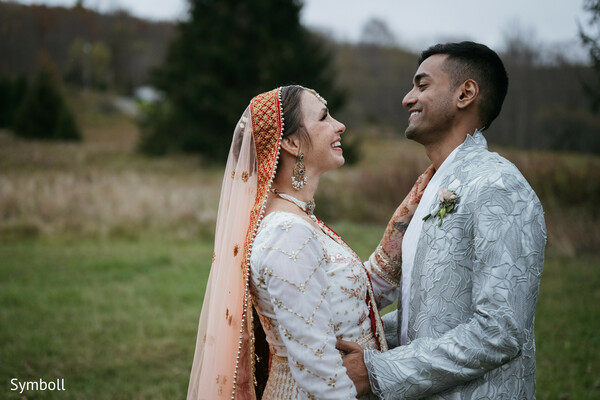 bride and groom laughter,ivory and gold lehenga,silver sherwani,romantic outdoor portrait,south asian couple,autumn wedding vibes,intimate wedding moment,soft countryside backdrop,traditional fusion attire,joyful newlyweds