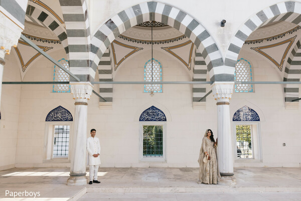 mosque-inspired architecture,arched column backdrop,ivory sherwani groom,champagne bridal outfit,islamic wedding aesthetic,architectural symmetry portrait,cultural wedding venue,editorial wedding photography,elegant nikah setting,traditional muslim attire