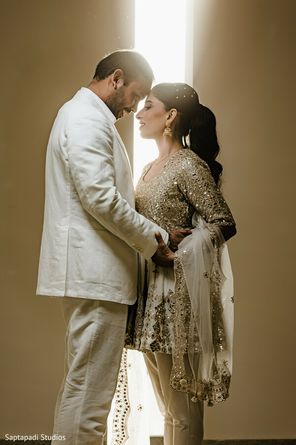 omantic couple portrait,gold bridal outfit,ivory groom suit,backlit wedding portrait,intimate wedding moment,south asian couple photography,elegant engagement portrait,luxury wedding style,golden light photography,emotional wedding portrait