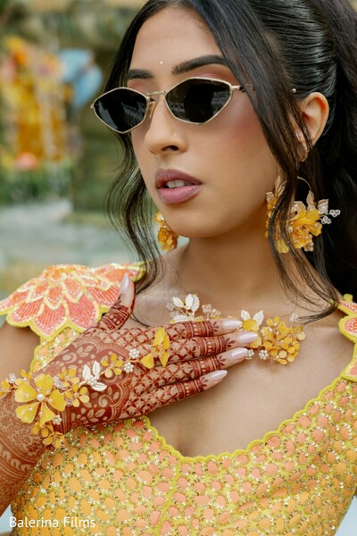 bridal mehndi details,haldi ceremony fashion,floral bridal jewelry,modern south asian bride,henna hand designs,yellow bridal outfit,bridal portrait close-up,stylish bridal accessories,pre-wedding ceremony look,indian wedding beauty details
