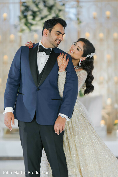 couple portrait reception,bride leaning on groom,romantic wedding pose,south asian wedding couple,navy tuxedo groom,ivory bridal gown,joyful wedding moment,elegant couple styling,reception photography,love and laughter