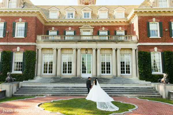 garden wedding portrait,bride and groom outdoor,classic wedding couple,romantic greenery backdrop,elegant wedding photography,bridal gown long train,south asian couple western attire,outdoor wedding shoot,luxury wedding portrait,timeless romance
