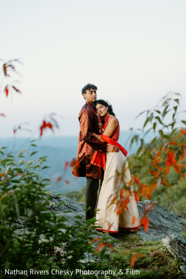 mountain couple embrace,romantic outdoor portrait,nature wedding photography,scenic love story,indian couple portrait,destination wedding shoot,intimate moment,soft foliage framing,south asian wedding couple,landscape romance