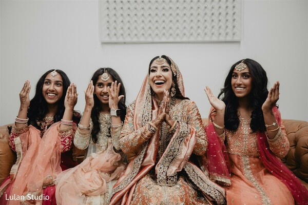 bride with bridesmaids,mehndi celebration,peach bridesmaid outfits,indian wedding prep,joyful bridal moment,bride laughing candid,pre wedding event,bridal squad,cultural wedding celebration,happy bride