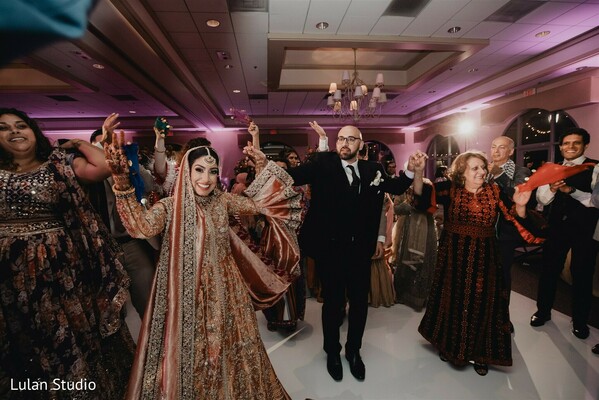 wedding dance floor,reception dancing,bride groom dancing,indian wedding party,celebration moment,guests dancing,joyful wedding,lively reception,wedding entertainment,party atmosphere