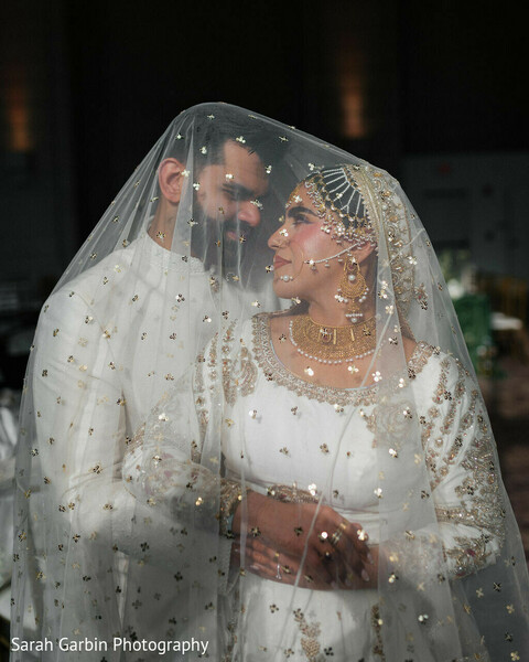 veil portrait couple,romantic close up,bride veil gold detail,intimate wedding moment,soft lighting portrait,bride jewelry detail,groom ivory sherwani,dreamy couple shot,emotional connection,indian wedding romance