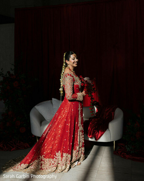 bridal portrait red lehenga,dramatic lighting bride,spotlight photography,elegant bridal pose,red wedding outfit,indian bride fashion,luxury bridal styling,solo bridal portrait,regal bride,bold wedding aesthetic