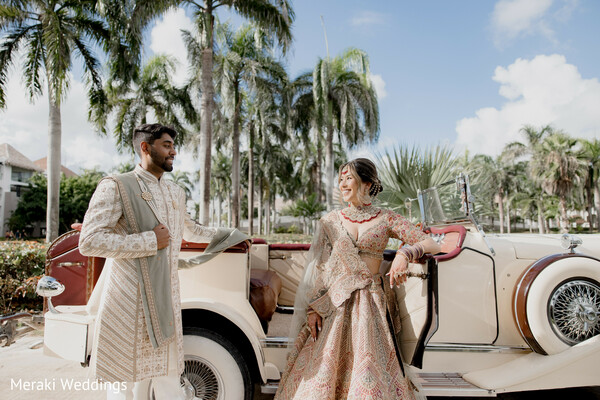 vintage wedding car,bride groom portrait,destination wedding palm trees,luxury wedding style,indian bridal lehenga gold,groom sherwani ivory,classic car wedding,couple posing outdoors,tropical wedding fashion,stylish wedding portrait