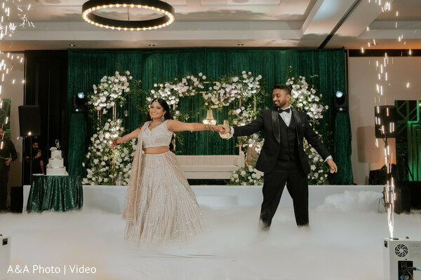 first dance wedding,couple dance moment,fog dance floor,cold sparks effect,reception entertainment,bride ivory lehenga,groom tuxedo dance,wedding party highlight,romantic dance scene,luxury reception moment