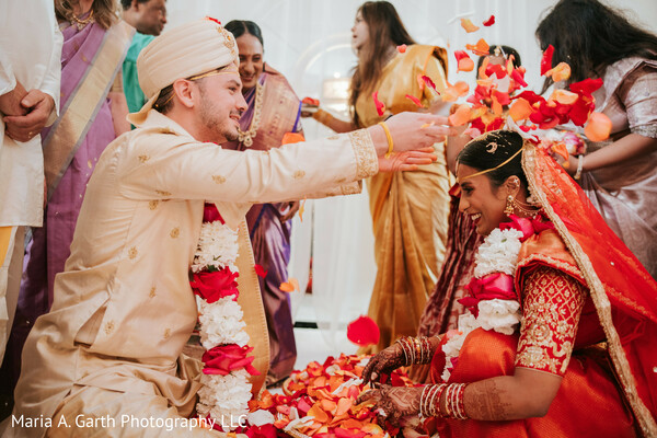 indian wedding ceremony,flower petal ritual,bride groom garlands,varmala moment,wedding ritual candid,couple ceremony interaction,traditional wedding customs,joyful ceremony moment,family surrounding couple,cultural celebration