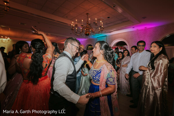 couple dancing reception,wedding dance floor candid,bride blue lehenga dance,groom vest suit,party atmosphere candid,guests surrounding couple,joyful dance moment,indian wedding reception vibe,candid celebration shot,nightlife wedding