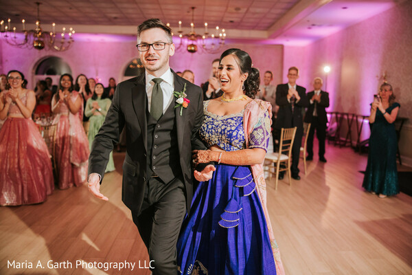 reception entrance couple,wedding celebration moment,bride blue lehenga,groom suit vest,party atmosphere wedding,guest applause moment,joyful couple entry,indoor reception lighting,indian wedding reception,candid celebration