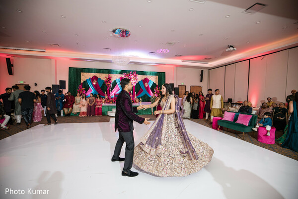 sangeet dance couple,bride twirling lehenga,groom velvet jacket,indian pre wedding event,dance floor moment,colorful sangeet decor,couple choreography,lively celebration,wedding dance candid,festive atmosphere