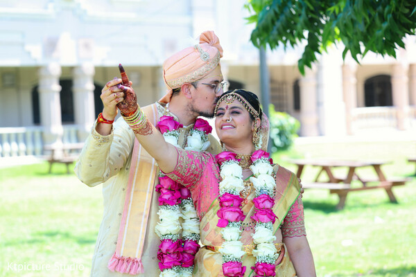 just married couple,floral garlands wedding,romantic couple moment,groom kissing bride,indian wedding garland ceremony,post ceremony portrait,candid love moment,bride groom happiness,traditional wedding couple,joyful wedding emotion