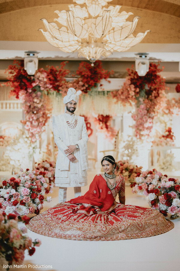 luxury wedding reception decor,floral stage backdrop,indian wedding stage,bride groom portrait reception,elegant wedding decor,floral installation wedding,romantic reception setup,couple stage pose,grand wedding styling,indoor wedding decor