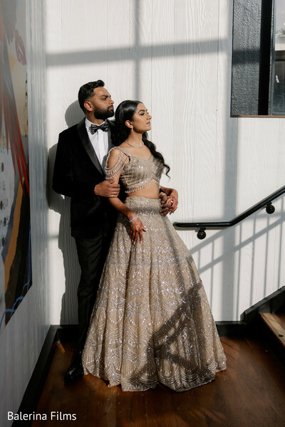 reception couple portrait,black tux groom,champagne lehenga bride,indoor wedding photography,editorial couple pose,luxury wedding style,modern elegance,sunlight shadows,romantic couple,formal wedding