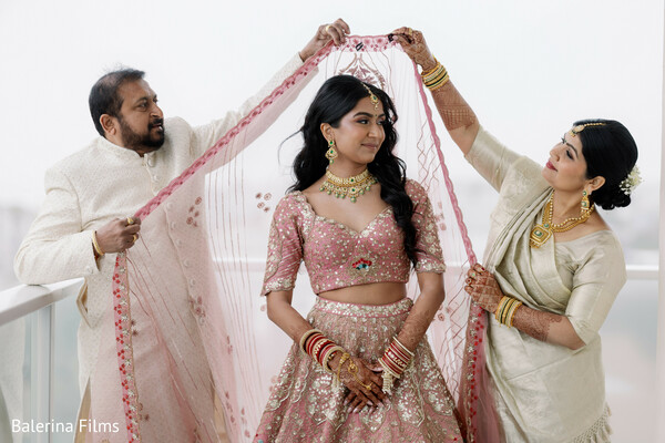 bridal getting ready,dupatta draping ceremony,family helping bride,indian wedding traditions,emotional wedding moment,bride preparation,cultural ritual,bridal jewelry and outfit,candid family moment,pre ceremony