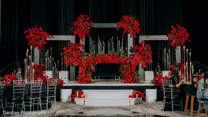 wedding stage decor,red floral wedding,luxury reception decor,indian wedding design,candlelight decor,floral installation,wedding styling,reception setup,elegant decor,event design