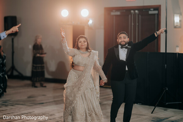 wedding reception entrance,couple entrance,bride and groom,celebration moment,indian wedding reception,joyful couple,party entrance,wedding dance floor,grand entrance,newlyweds