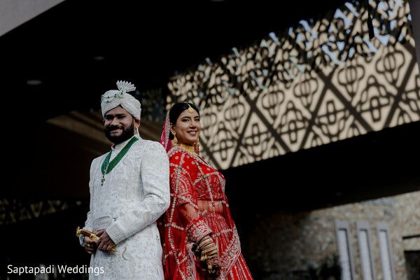 bride and groom portrait,red bridal lehenga,ivory sherwani,wedding day fashion,maharani bride,traditional indian wedding,bridal jewelry,groom turban,luxury wedding attire,outdoor wedding portrait
