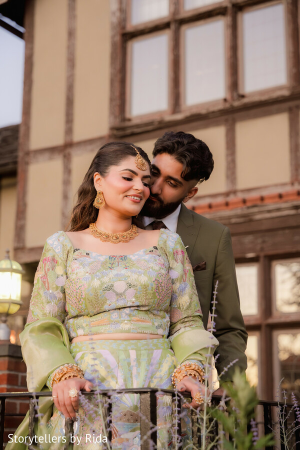 estate portraits,floral lehenga,olive green suit,romantic couple,balcony portraits,luxury engagement session,south asian fashion,elegant romance,outdoor venue,couple photography