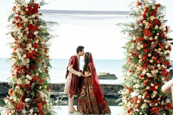 ceremony kiss,floral arch,oceanfront wedding,romantic moments,destination wedding,luxury floral decor,bride and groom,beach ceremony,wedding portraits,seaside romance