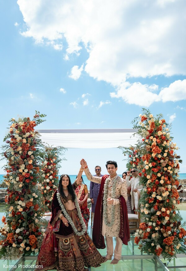 beach ceremony,floral mandap,oceanfront wedding,newlyweds celebration,destination wedding,bride and groom,luxury floral decor,wedding exit,seaside vows,romantic ceremony