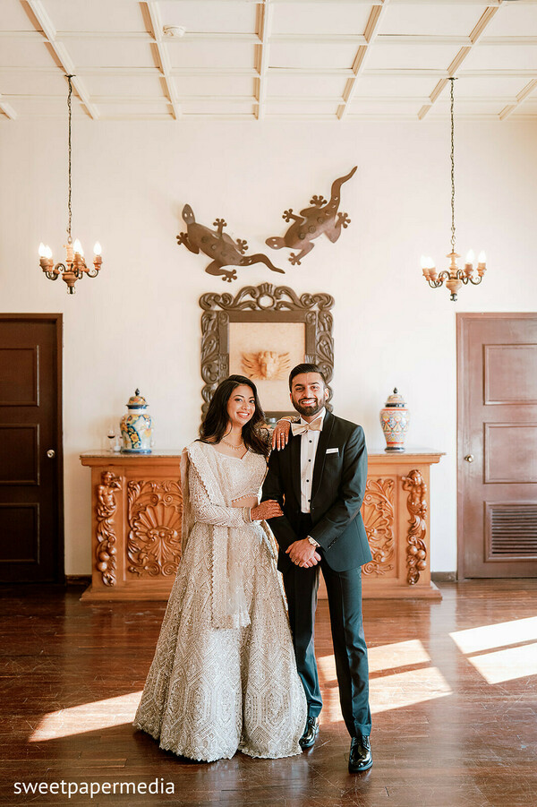 couple portraits,ivory lehenga,black tuxedo,reception attire,luxury wedding,elegant venue,indoor portraits,fusion wedding,formal fashion,bride and groom
