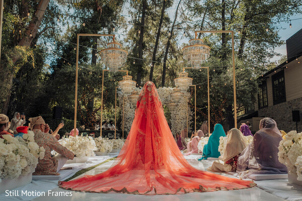bridal entrance,ceremony aisle,red veil,luxury decor,wedding ceremony,dramatic entrance,chandeliers,bridal fashion,wedding day moments,south asian wedding