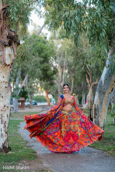 bridal portraits,twirling bride,colorful lehenga,outdoor portraits,wedding fashion,south asian bride,movement photography,garden portraits,bridal style,vibrant colors
