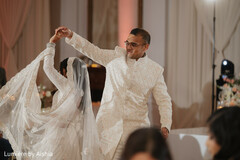 Indian Couple Dancing in White Sherwani & Lehenga at Wedding Reception