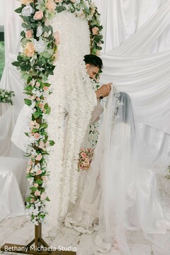 Couple Under Floral Arch with White Draping Ceremony