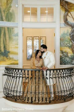 Couple in Gold Attire on Ornate Balcony