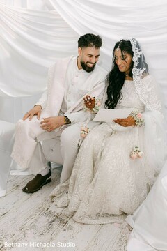 Couple in White Attire Looking at Document