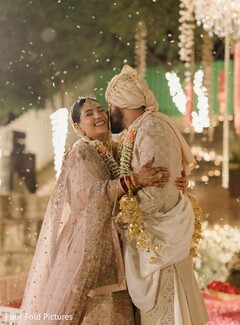 Joyful Couple in Traditional Attire with Floral Garlands
