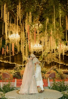 Couple Under Floral Chandeliers and String Lights