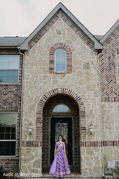 Indian Bride in Purple Lengha Posing at Home Entrance